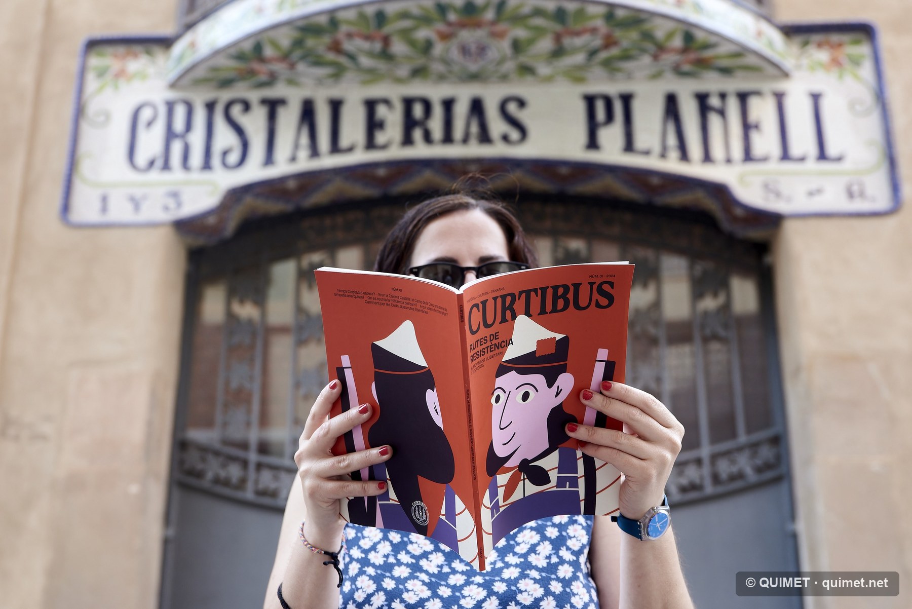 Lectora davant la façana de Cristalleries Planell